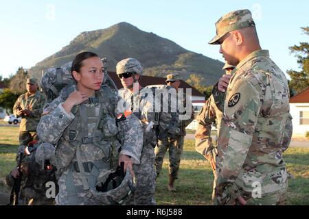 La CPS. Nicole D. Cruz de la Guam obtient la garde nationale des directives de son cadre, le Sgt. 1re classe Kevin Dirige, avant de l'épuisant 12-mile ruck sack mars mai 18 au cours de la Garde nationale 2017 Région Bureau VII CONCOURS Meilleur guerrier 17 mai à San Luis Obispo, Californie. Banque D'Images