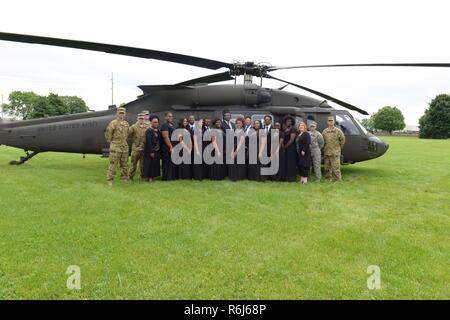 Les membres de la chorale de l'école haute ondulation large et leurs membres d'équipage de la 38e Brigade d'aviation de combat posent pour une photo en face de l'un des nouvel avion dans la Garde nationale de l'Indiana, un Black Hawk UH-60M hélicoptère, dimanche 21 mai 2017 à Indianapolis. La Garde nationale de l'Indiana a organisé une cérémonie pour les nouveaux avions à la 38ème Division d'infanterie, l'administration centrale. La grande chorale de l'école chantent l'hymne national et de "retour à l'accueil de nouveau en Indiana" pendant la cérémonie. Banque D'Images
