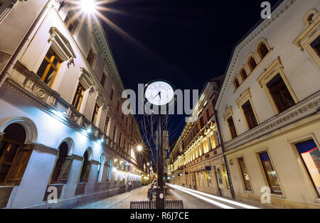 Horloge ancienne sur la rue Piotrkowska, Lodz, Pologne dans la soirée. Banque D'Images