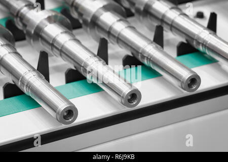 Fabrication de produits métalliques, les arbres ou les bagues se situent sur une bande transporteuse, concept industriel Contexte Banque D'Images