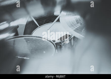 Le batteur jouant sur un ensemble de batterie vue d'en haut. Musique live, concert band au cours de la performance. Voir et regarder par cymballs allong sur caisse claire et baguettes de tambour Banque D'Images