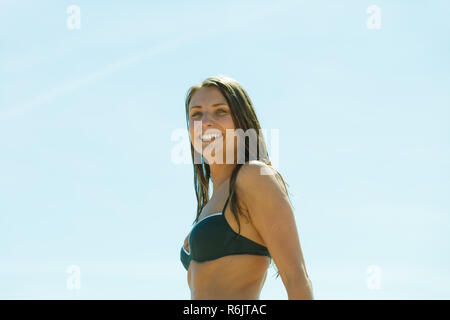 La joie d'été loisirs d'été, à l'extérieur de concept. Woman in Black bikini maillot de s'amuser à l'extérieur. Ciel bleu en arrière-plan. Banque D'Images