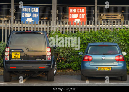 Londres, ANGLETERRE - Mai 2018 : des signes de couleur sur la clôture d'un garage de stationnement près de l'aéroport d'Heathrow montrant drop off arrangements, avec des voitures garées en t Banque D'Images