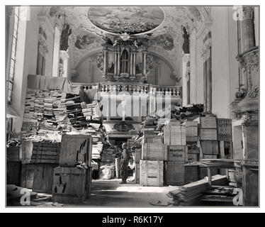 Pillage butin Nazi Vintage WW2 Seconde Guerre mondiale militaire américain 'Monument ' hommes rencontrés butin nazi allemand référentiels tels que celui de toute l'Europe. Ici, des piles de boîtes, records, et les vêtements sont gardés par un GI américain à l'intérieur d'une église à Ellingen, Allemagne. L'église avait été utilisé par les Nazis comme un dépôt secret pour quisitioned "vêtements" de Belgique La France et la Hollande 1945 Banque D'Images