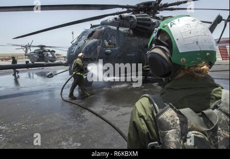 MANAMA, Bahreïn (18 mai 2017) marins affectés à l'hélicoptère de la lutte contre les mines (HM) de l'escadron 15, laver un MH-53E Sea Dragon avant de mener la lutte contre les mines la formation. HM-15 est assigné à la Force 52, la promotion des activités de lutte contre les mines dans la 5e flotte américaine zone d'opérations. Banque D'Images