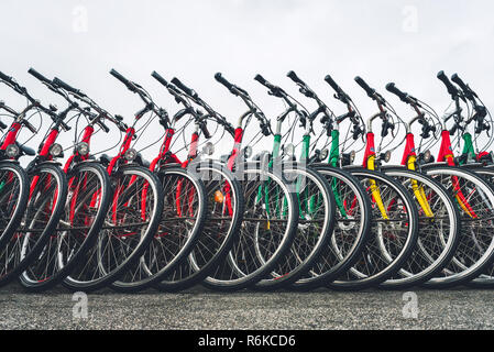 Vélos debout dans une rangée sur la ville street Banque D'Images