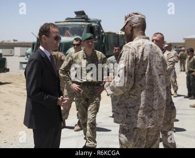 Le colonel David Gibbs, droite, commandant de la police de l'équipe, Groupe de travail sud-ouest accueille l'Honorable Dominic Jermey, gauche, l'Ambassadeur britannique en Afghanistan et le major général Martin Smith, centre, à titre de conseiller pour le ministère de l'intérieur, à l'Aérodrome de Bost dans la province de Helmand, Afghanistan, le 24 mai 2017. Le colonel Gibbs a montré la présence de visiteurs autour de l'enceinte qui abrite à l'Administration centrale et la zone 505ème Marines des États-Unis avec la Force sud-ouest. Environ 300 marins et Marines avec la Force au sud-ouest sont la formation, de conseiller et d'aider l'Armée nationale afghane Co 215e Banque D'Images