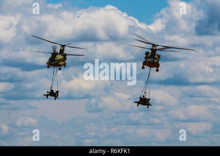 Deux Boeing CH-47 Chinook's fly zone sur la Sicile avec M777A2 configuré pour l'obusier à air comprimé, la charge sous élingue, opération au cours de la 82nd Airborne Division aéroportée de l'examen, situé sur le Fort Bragg, N.C., 25 mai 2017. L'examen en vol est l'événement culminant de tous les Américains sur 7 100 qui est l'occasion pour les parachutistes, anciens et actuels, pour célébrer le fait d'être membres de l'America's garde d'honneur. Le thème de la semaine All American 100 est, 'célébrer un siècle de service !" Banque D'Images