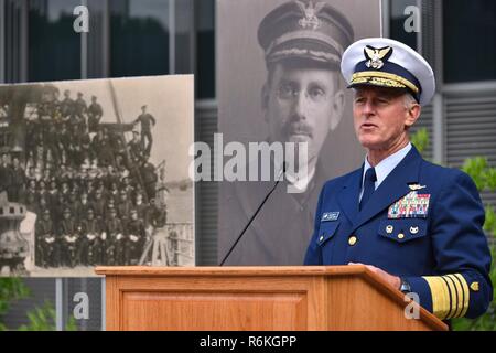 Commandant de la Garde côtière canadienne Adm. Paul Zukunft parle devant une photo de l'équipe de Tampa garde-côte au cours d'une célébration de la Journée du souvenir à la Douglas A. Munro du bâtiment du siège de la Garde côtière canadienne à Washington, D.C., le 26 mai 2017. La Faucheuse Tampa a été torpillé après avoir escorté un convoi de Galles en 1918, entraînant la perte de toutes les 131 personnes à bord. La Garde côtière américaine Banque D'Images