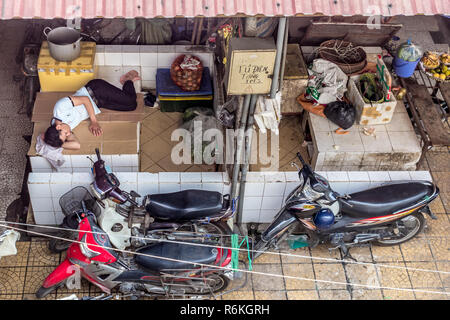 Hanoi, Vietnam - CIRCA Octobre 2015 : Jeune homme fatigué, épuisé dans des shirt dort à l'arrière du fruit et marché aux poissons à Hanoi, Vietnam. Banque D'Images