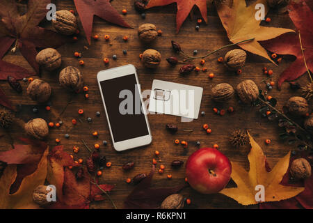 Téléphone mobile et la carte SIM à l'arrangement d'automne. Vue supérieure de la mise à plat de votre smartphone à l'écran la maquette vierge que copier l'espace. Banque D'Images