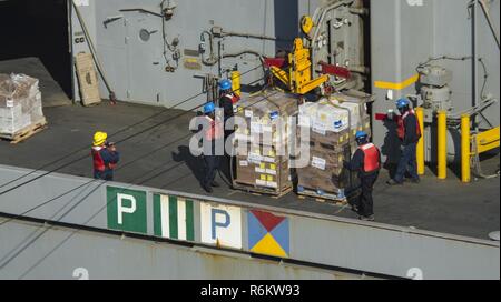 Pacifique occidental (19 mai 2017) du personnel du Commandement du transport maritime militaire à bord de la classe de Lewis et Clark les cargaisons sèches et de munitions ship USNS Wally Schirra (T-AKE 8) rig cargo pour un connecté reconstitution transfert à la classe Nimitz porte-avions USS Carl Vinson (CVN 70). La Marine américaine a patrouillé les Indo-Asia-Pacifique couramment pour plus de 70 ans la promotion de la paix et la sécurité régionales. Banque D'Images