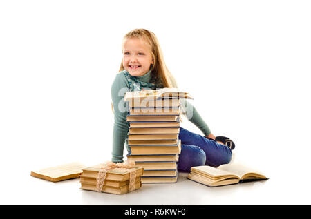 Petite fille avec beaucoup de livres isolé sur fond blanc Banque D'Images