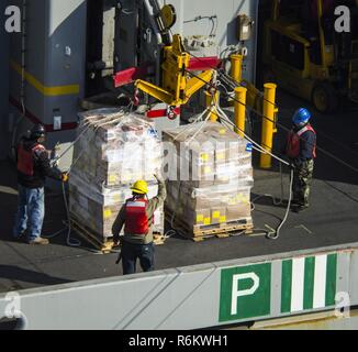 Pacifique occidental (19 mai 2017) du personnel du Commandement du transport maritime militaire à bord de la classe de Lewis et Clark les cargaisons sèches et de munitions ship USNS Wally Schirra (T-AKE 8) rig cargo pour un connecté reconstitution transfert à la classe Nimitz porte-avions USS Carl Vinson (CVN 70). La Marine américaine a patrouillé les Indo-Asia-Pacifique couramment pour plus de 70 ans la promotion de la paix et la sécurité régionales. Banque D'Images