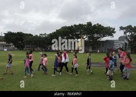 Les enfants de l'école élémentaire Kadena à pied de l'un stand d'éducation à l'autre 22 mai 2017, à Kadena Air Base, au Japon. L'école d'anglais langue seconde équipe a présenté 12 stations représentant le Livre Guinness des Records pour l'ensemble de l'école. Banque D'Images