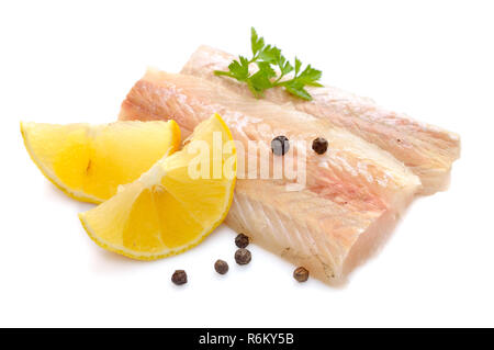 Merlu cru morceaux de filet de poisson avec du citron. Isolé sur fond blanc. Banque D'Images