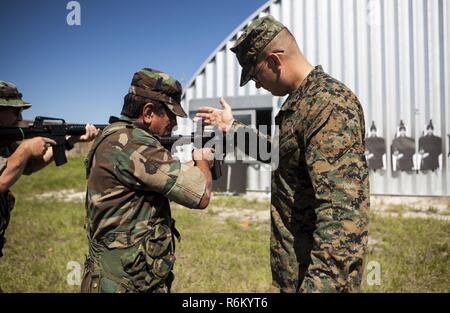 Le Sgt. Ethan J. Wright enseigne l'adresse au tir d'un rôle player au cours de l'exercice Général 2 Base du Corps des Marines à Camp Lejeune, en Caroline du Nord, le 3 mai 2017. Les Marines menées la répétition générale de l'exercice Cours Conseiller maritime afin d'évaluer leur préparation à la formation des forces de sécurité étrangères lors de leur prochain déploiement en Amérique centrale. Wright est un instructeur de tactiques avec le sol, l'élément de combat air-sol marin à des fins spéciales Task Force - Southern Command. Le conseiller maritime cours est donné par le Groupe de coopération en matière de sécurité du Corps des Marines. Banque D'Images