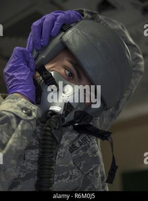 U.S. Air Force d'un membre de la 1re classe Dallas Galvan, un équipage avec le technicien d'équipement de vol 379e Escadron de soutien opérationnel expéditionnaire, boucles La MBU-20/P dans le masque HGU-55/P casque en Al Udeid Air Base, au Qatar, le 16 mai 2017. Galvan est effectuer une inspection qui vérifie le fonctionnement du microphone, casque et bouteille d'oxygène en branchant le MBU-20/P en masque un testeur qui simule les fonctions d'aéronefs et la pression de l'air. Banque D'Images