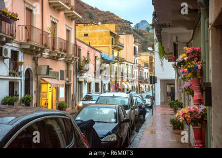 Cityscape with scenic vacances maisons et rue piétonne au crépuscule pluvieux à Giardini Naxos, près de Taormina. Sicile, Italie Banque D'Images