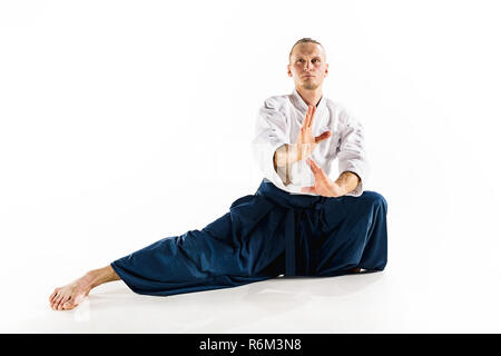 Maître d'Aikido la posture de défense des pratiques. Style de vie sain et de sport concept. Homme avec barbe en kimono blanc sur fond blanc. Banque D'Images