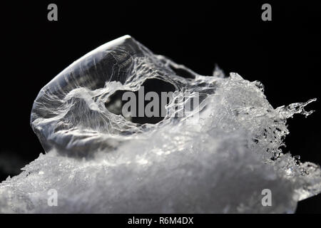 Une bulle de savon gelés dans la neige avec un trou en forme de coeur. une bulle de savon cassé ressemble à un alien egg Banque D'Images