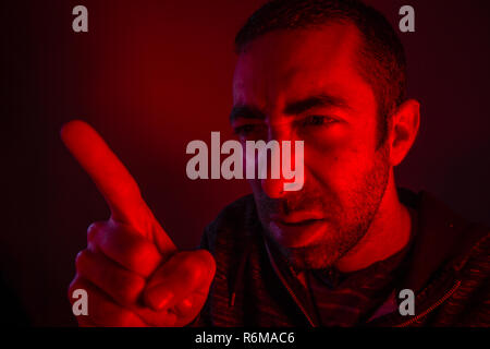 Portrait d'un homme avec l'expression du visage en colère pointant son index Banque D'Images