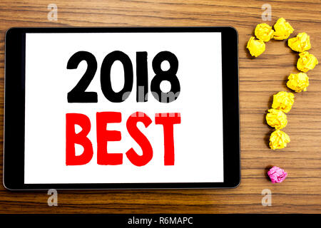 L'écriture de texte montrant 2018 meilleure. Concept d'affaires Choix de revue écrite sur ordinateur tablette sur le fond en bois avec un point d'interrogation fait de papier plié. Banque D'Images