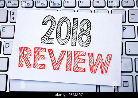 Légende manuscrite indiquant l'examen 2018. Concept d'affaires écrit des commentaires sur les progrès écrit sur sticky note sur le clavier blanc arrière-plan. Banque D'Images