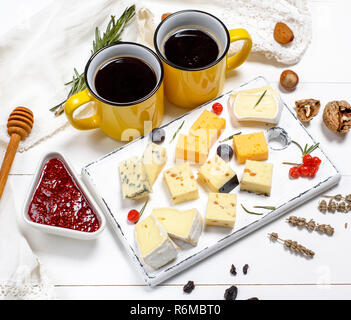 Morceaux de fromage sur une planche de bois blanc Banque D'Images