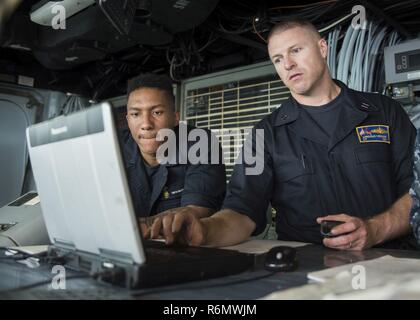 NORFOLK, Virginie (31 mai 2017) Le lieutenant Kerger, Lincoln Navigator du navire, matelot timonier trains Dimitri Whitman lors d'une vitesse de croisière à bord du navire d'assaut amphibie USS Wasp LHD (1). Une vitesse de croisière se compose d'essais de matériel, des simulations et des scénarios qui rafraîchir et de former des marins pour les périodes en cours. Le Wasp est actuellement l'objet d'une période de constitution de la disponibilité progressive prévue à BAE Systems Naval Shipyard tandis que les préparatifs de son prochain port d'attache passage à Sasebo, au Japon. Banque D'Images