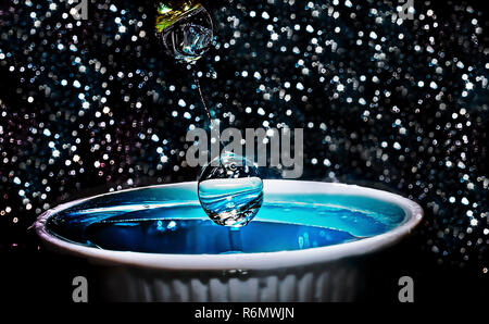 Une goutte d'eau est arrêté avec une grande vitesse d'obturation et suspendue en l'air avant de tomber dans un plat d'eau, le 21 janvier 2016. Banque D'Images