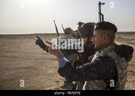 Un Guardia Civil espagnole formateur parle à un membre des forces de sécurité irakiennes au cours de formation au tir à courte portée à la gamme Besmaya complexe, l'Iraq, le 30 mai 2017. Cette formation fait partie de la Force opérationnelle interarmées combinée globale - Fonctionnement résoudre inhérent à renforcer les capacités des partenaires mission par la formation et de l'amélioration de la capacité des forces des combats en partenariat avec ISIS. Les GFIM-OIR est la Coalition mondiale pour vaincre ISIS en Iraq et en Syrie. Banque D'Images