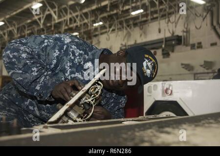 NORFOLK, Virginie (31 mai 2017) Technicien d'équipement de soutien à l'Aviation 2e classe Buah La Justice s'occupe de l'entretien d'un spotting dolly dans la zone du porte-avions USS Dwight D. Eisenhower (CVN 69) (Ike). Ike est en ce moment pier côté pendant la phase de maintien en puissance de la flotte (Plan d'intervention optimisés OFRP). Banque D'Images