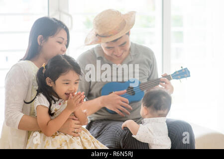 Asian family playing ukulele Banque D'Images