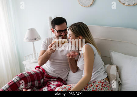 Young attractive couple having breakfast in bed Banque D'Images