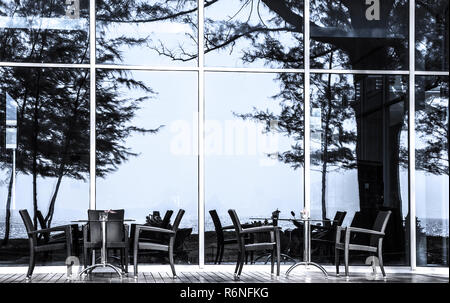 Des tables et des chaises en face de la façade de verre s'Nai Yang Beach, île de Phuket, Thaïlande. Banque D'Images