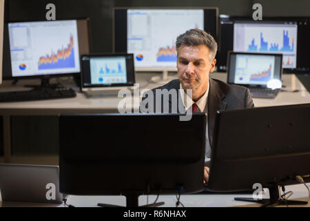 Businessman Working On Multiple Computer Banque D'Images