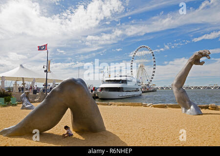 OXON HILL, Maryland, États-Unis - 11 septembre 2016 : un enfant jouant dans l'ombre d'une sculpture géante appelée Awakening au front de mer de Port National. Oxon Banque D'Images