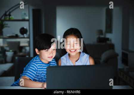 Les enfants partageant l'ordinateur portable à la maison