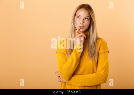 Portrait of a young woman dressed in sweater isolés sur fond jaune, à l'écart Banque D'Images