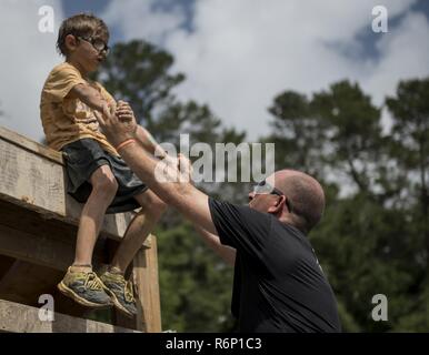 Aidan Flippo, pilote d'un jour, le candidat remplit un obstacle avec son père le s.. Dustin Flippo, Eglin Air Force Base noncomissioned la garde d'honneur, officier responsable d'un organisme de bienfaisance au cours de boue-exécuter le 20 mai 2017, à Niceville, en Floride. Flippo a été choisi pour être la 33e Escadre de chasse est pilote d'un jour. Aidan est né avec la Dysplasie Septo optique quels effets les yeux et les reins. Au cours de sa journée, il a rencontré les pilotes de F-35, a visité un avion, a travaillé avec les responsables d'avions et bien plus encore. Banque D'Images