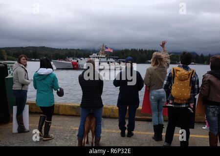 Les familles attendent le retour de leurs proches stationnés à bord du garde-côte de Barco Bailey (WPC 1122) arrivant à son nouveau port d'attache à l'amarrage de la base de la Garde côtière canadienne au cours d'une cérémonie de retrouvailles Ketchikan à Ketchikan, Alaska, le 12 mai 2017. La réponse rapide de la faucheuse et son équipage a réalisé un voyage de 6 200 milles, Key West, Floride. Photo de la Garde côtière des États-Unis. Banque D'Images