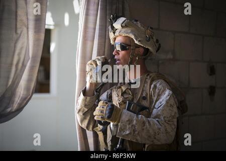 MARINE CORPS AIR GROUND COMBAT CENTER Twentynine Palms, California - Le Cpl. Kevin Masellah, un squadleader avec 3e peloton, Compagnie de Golf, 2e Bataillon, 7e Régiment de Marines, communique à ses coéquipiers de l'ennemi à l'éventail 200 au cours d'un exercice d'entraînement à bord de voie urbaine Marine Corps Air Ground Combat Center, Twentynine Palms, California, 15 mai 2017. L'ensemble de combat en zone urbaine, une partie de l'exercice de formation intégrée, 3-17 est un niveau de peloton à l'évolution de la taille d'un bataillon de marines où pratiqué patrouilles, conduisant à une masse d'Air Maritime Task Force attaque contre un ennemi a tenu la ville. Il Banque D'Images