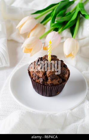 Muffins au chocolat d'anniversaire ou capkakes et tulipes. Banque D'Images