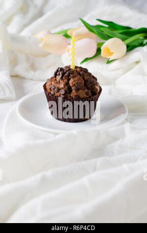 Muffins au chocolat d'anniversaire ou capkakes et tulipes. Banque D'Images