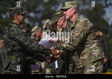 Le Sgt commande. Le Major Shawn Carns de la Force opérationnelle - Bravo mains un diplôme et félicite un soldat du Honduras pour la fin de la formation par le 2e Bataillon des Forces alignées à l'échelle régionale, 153e Régiment d'infanterie, 39e Brigade d'infanterie de l'équipe de combat à Tamara, le Honduras, le 18 mai 2017. Le 2 - 153e, 39e de l'IBCT La Garde nationale de l'Arkansas soutient la mission de la RAF avec ses pays hôtes du Guatemala, El Salvador et le Honduras. Banque D'Images