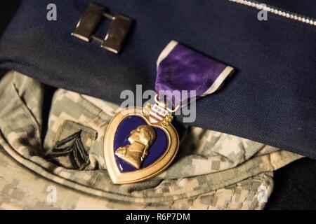 La Purple Heart décerné à Capitaine Kevin Summerbell, après son tour de service en Irak, se trouve sur le dessus de l'avion cap il porte aujourd'hui et sa vieille couverture de l'armée le 4 avril 2017. Summerbell a été enrôlé dans l'armée en tant que fantassin avant la mise en service dans l'Armée de l'air. Il a été déployé en Irak à deux reprises au cours de son temps dans l'armée et a reçu un Purple Heart pour ses blessures et de courage sur le champ de bataille. Summerbell a obtenu son baccalauréat, à l'école de pilotage et terminés ROTC, puis est devenu un C-17 pilote à la 437e AW. Banque D'Images