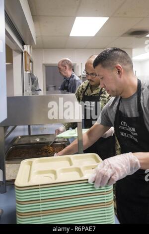 PORTLAND, OREGON (17 avril 2018) Marine l'Adjudant-chef 2 Edwin Kim (avant), lutter contre l'avenir du fret à bord du USS Portland (LPD 27), Technicien de coque et de 2e classe Marcos Marmolejo, préparer des plaques pour servir à la population de sans-abri à l'équipe de ministères Ville soupe populaire, 17 avril. Portland est en ce moment à Portland, Oregon préparer sa cérémonie de mise en service officielle. Il est le 11e de la marine américaine de classe San Antonio de transport amphibie Navire dock. C'est le troisième navire à porter le nom USS Portland, cependant il est le premier navire à être nommés pour la plus grande ville de l'Oregon. Banque D'Images