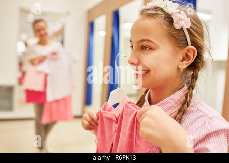 Fille attend avec intérêt de l'achat d'une robe à la mise en place d'une boutique Banque D'Images