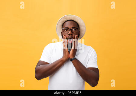 Portrait de goofy surpris bug-eyed jeune homme à la peau sombre student wearing Casual t-shirt blanc à regarder caméra avec air choqué. Banque D'Images